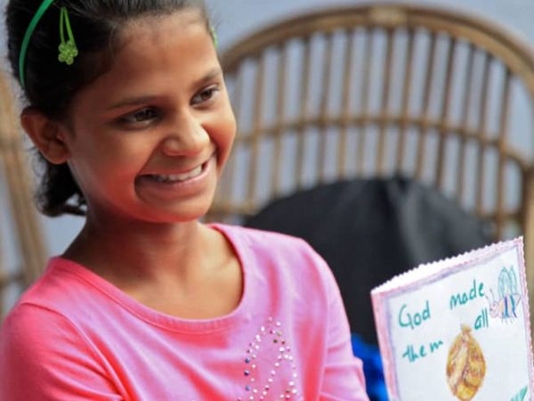 young girl holding hand made card